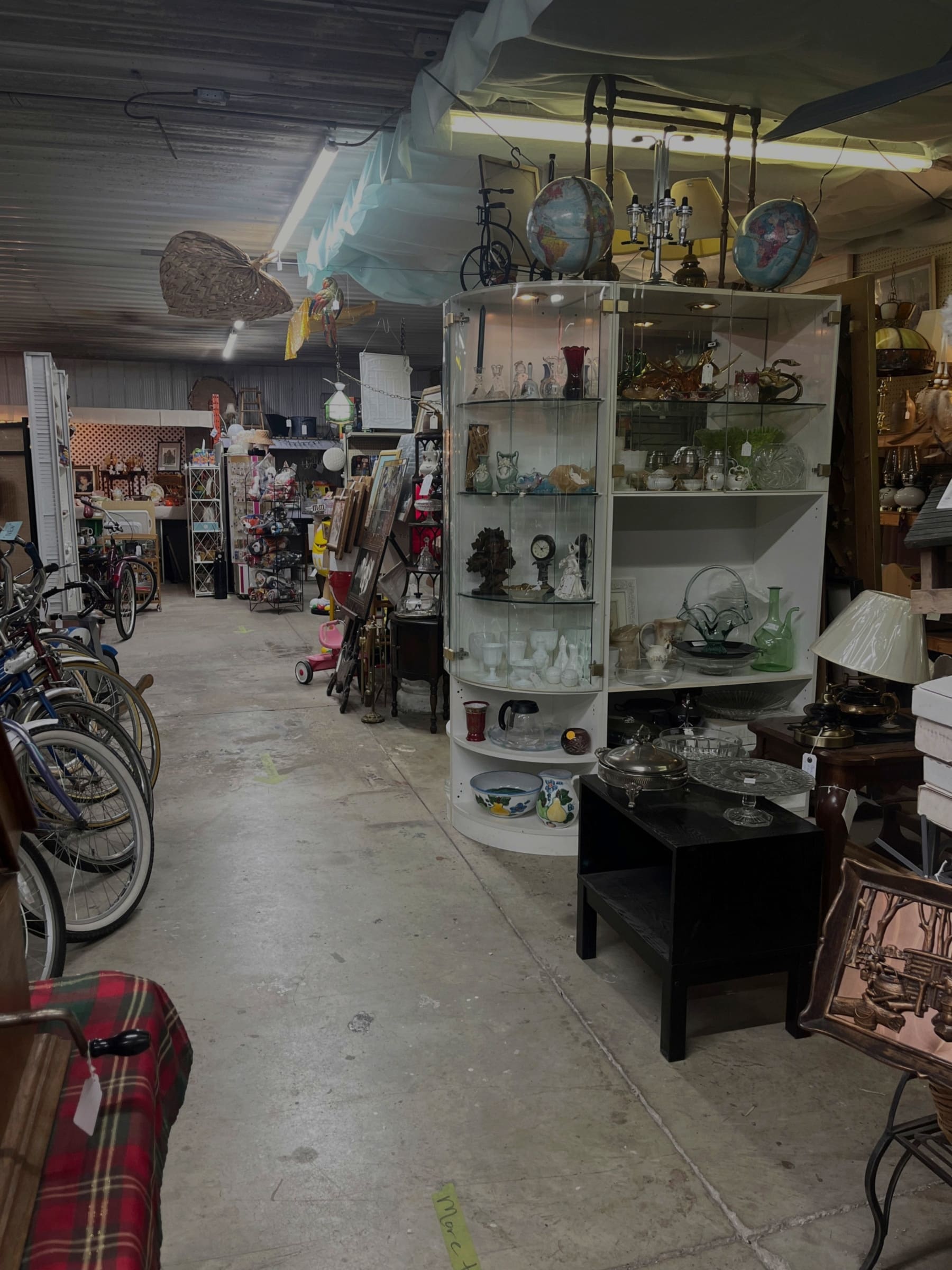 Vintage bicycles and a glass display cabinet along a market aisle