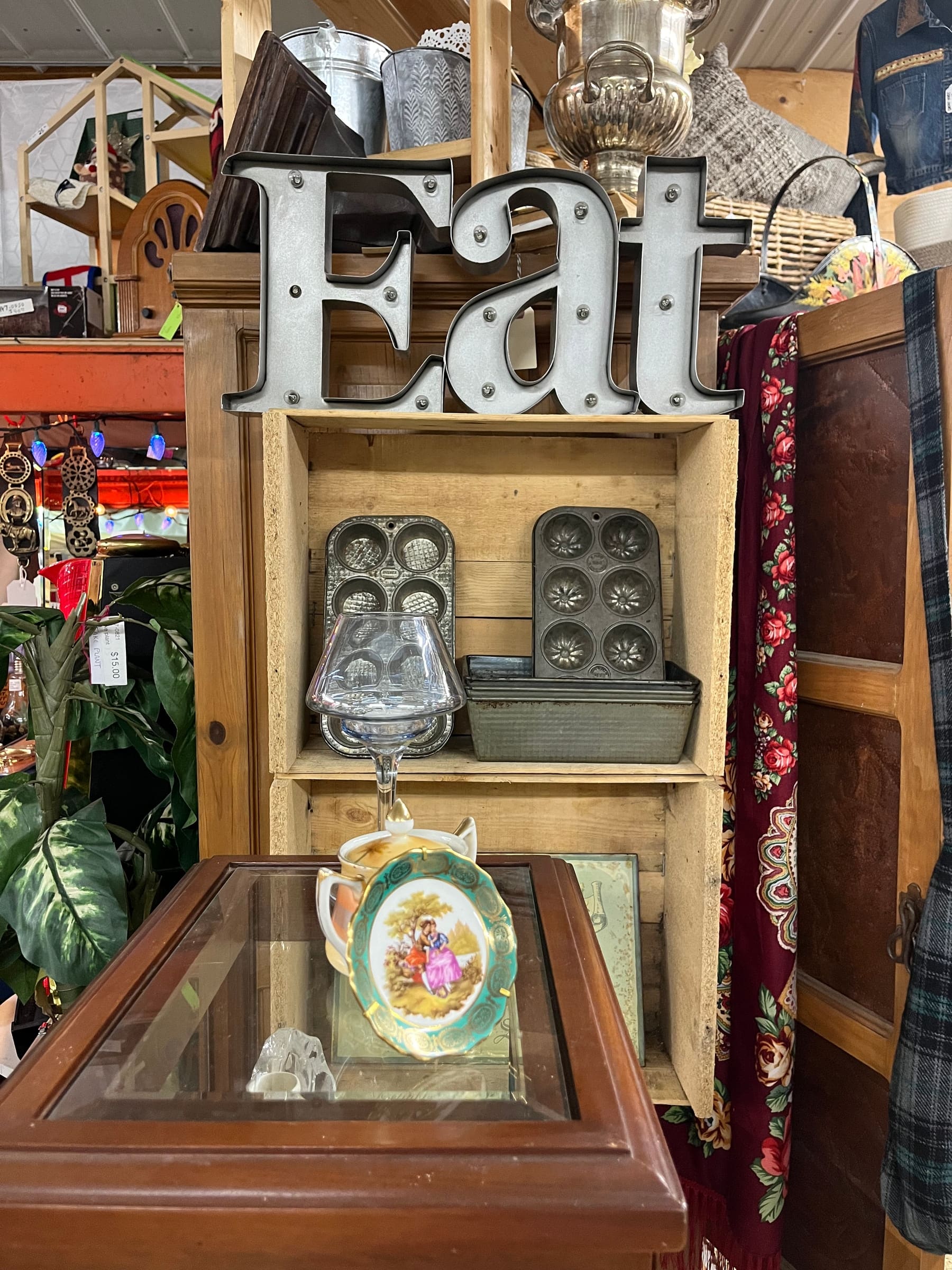 Vintage kitchenware under a large metal EAT sign